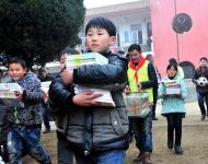 2016年1月8日下午,在駐馬店市汝南縣三門閘街道大新莊小學校院內(nèi)，駐馬店市陽光助學協(xié)會負責人及志愿者、大新莊學校師生、學生家長歡聚一堂，舉行了“陽光助學愛心圖書室”捐贈儀式。圖為學生和志愿者一起搬運新書
