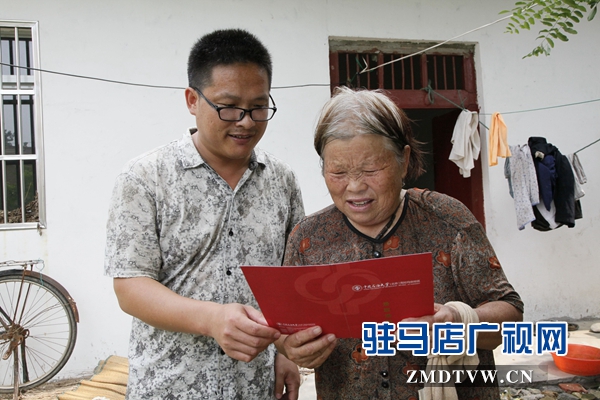 媽媽拿著兒子大紅色的大學(xué)錄取通知書，心里很美。.jpg