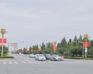 駐馬店市開(kāi)源大道，道路兩旁清一色的紅旗在迎風(fēng)飄揚(yáng)。所有紅旗都是在燈桿的一側(cè)逆時(shí)針旋轉(zhuǎn)90°豎著懸掛，鮮艷的國(guó)旗整齊地朝向一側(cè)，非常壯觀。