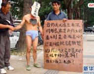 2011年11月22日，深圳福田區(qū)東園路上，河南籍農(nóng)民工韓文德雇人頭戴“黑心老板”面具，只穿一條內(nèi)褲走在街上，這么做是為了討要承包方欠下的21萬元工錢。他表示，自己和13名老鄉(xiāng)去年底參與深圳某大廈外墻翻新工程，今年8月完工后沒拿到應得的工資，希望這樣的方式能引起有關方面的重視。經(jīng)記者調(diào)查發(fā)現(xiàn)，勞資雙方的合同沒有文字憑據(jù)，成了一筆死無對證的“糊涂賬”。新華社發(fā)