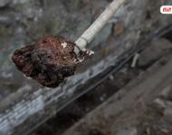 在遷安市中化煤化工有限責(zé)任公司的圍墻外是污水排放溝，溝里的泥成為紅褐色。