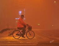 2017年1月4日早晨，一名環(huán)衛(wèi)工人在大霧中的安徽阜陽街頭騎行。盧啟建/視覺中國