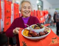 1月4日，內(nèi)蒙古呼和浩特市玉泉區(qū)清泉街社區(qū)一位老人在展示臘八粥食材。當(dāng)日，呼和浩特市玉泉區(qū)清泉街社區(qū)舉辦“溫暖臘八粥 濃濃鄰里情”活動，喜迎即將到來的“臘八節(jié)”。新華社發(fā) 丁根厚 攝