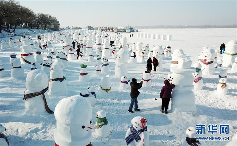 1月2日，市民、游客在雪人群中游玩觀賞（無人機拍攝）。2019個各式各樣的雪人，近日在冰城哈爾濱市的松花江畔亮相，引來眾多市民游客游玩觀賞。新華社記者 王建威 攝